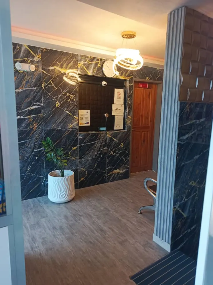 Habitación en penumbra con cabecera azul y luz cálida